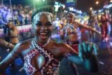 Colorful caribbean carnival women dancing in street